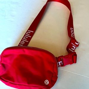 Red Lululemon belt bag with spell out on strap